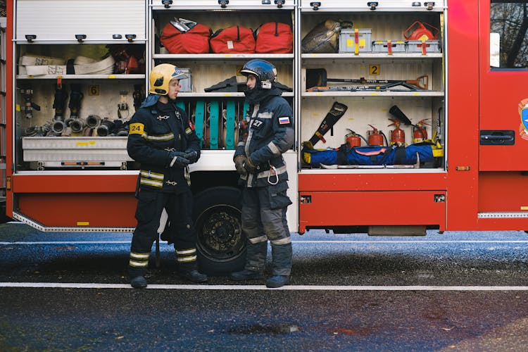 Firefighters Talking By Fire Engine