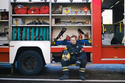 Man Smiling while Sitting on Running Board of a Fire Truck