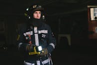 Man Wearing Turnout Gear Holding a Flashlight