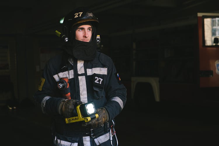 Man Wearing Turnout Gear Holding A Flashlight