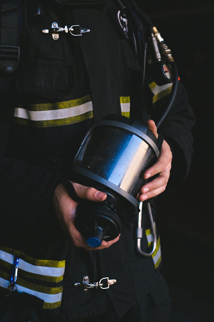 A Firefighter Holding A Mask