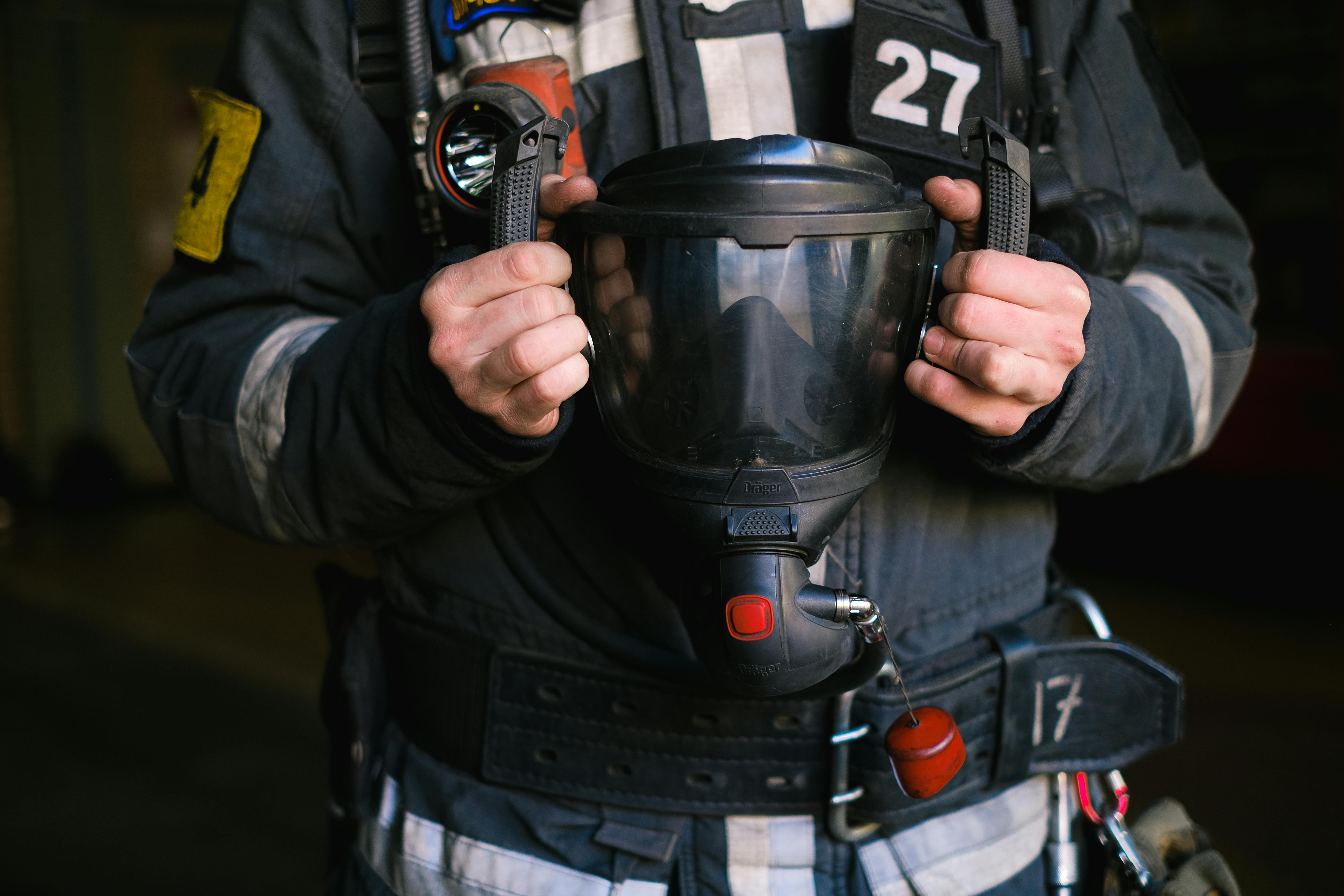 Free Close-up of a firefighter holding a protective helmet, showcasing emergency gear. Stock Photo