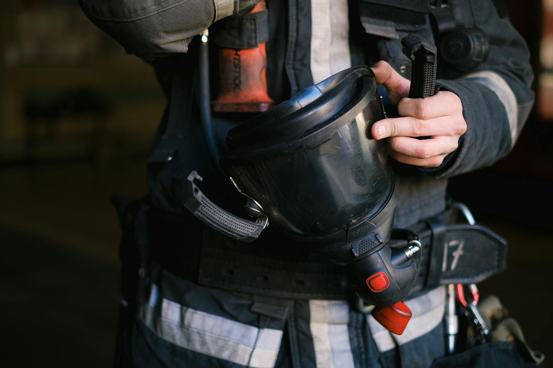 Person Holding a Black Gas Mask