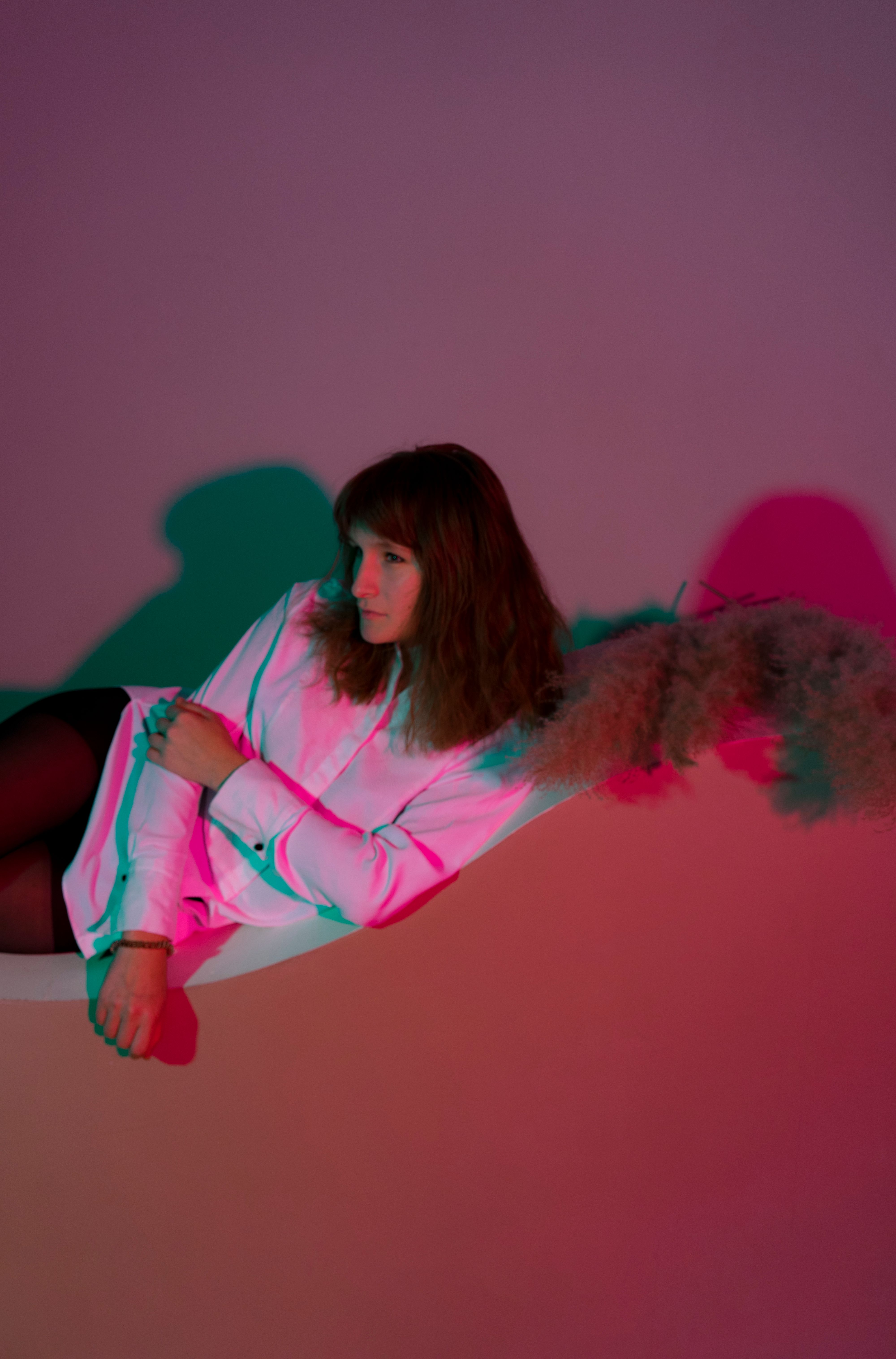 Emotionless woman lying on stand in dark room · Free Stock Photo
