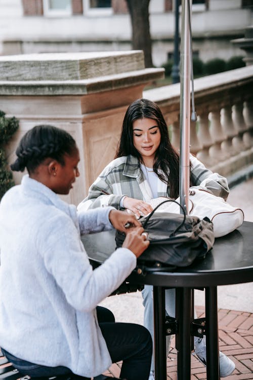 Young diverse women talking at table