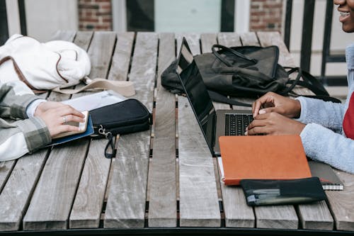 Person, Die Schwarzen Laptop Computer Auf Braunem Holztisch Verwendet