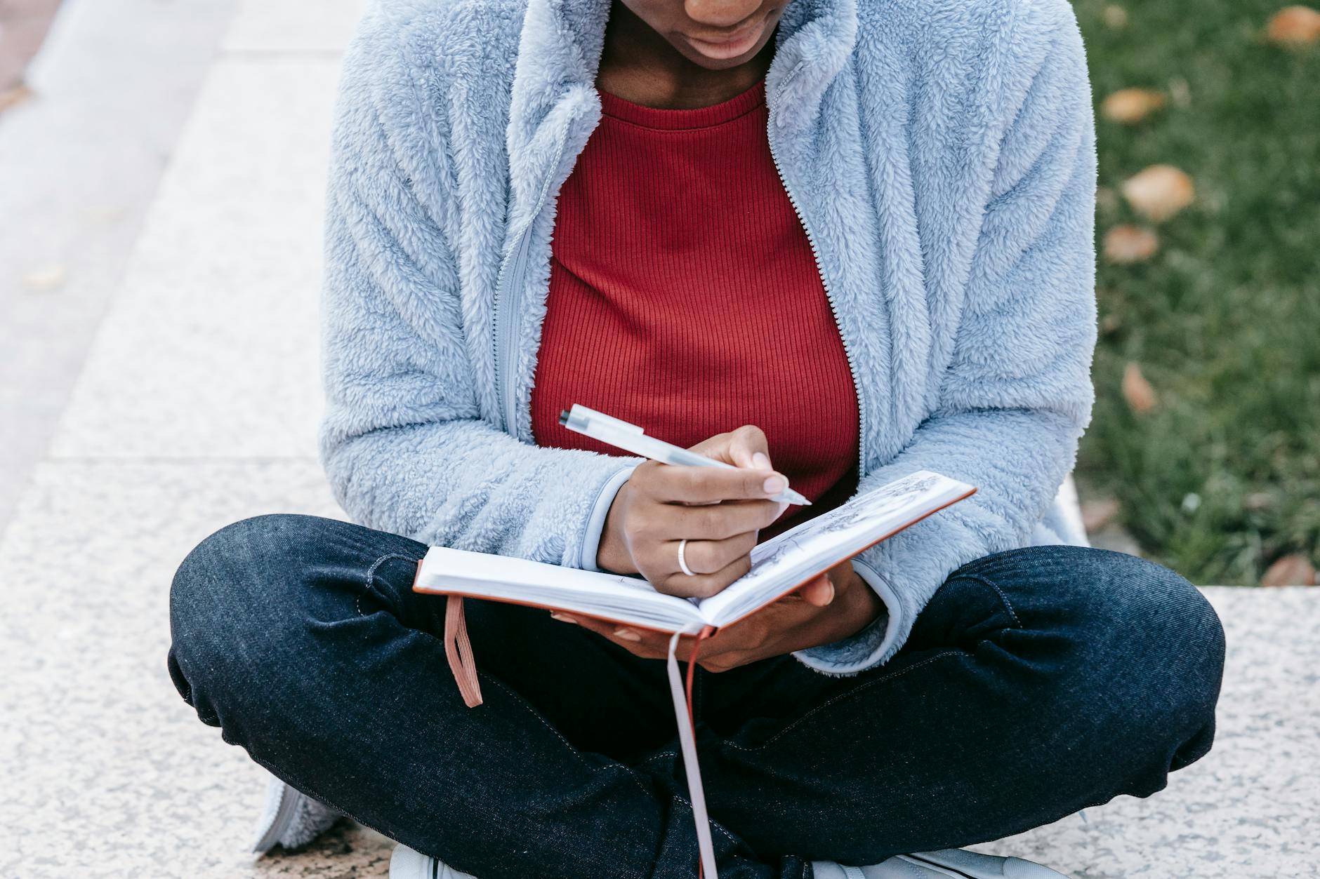 Crop black student with diary studying in town