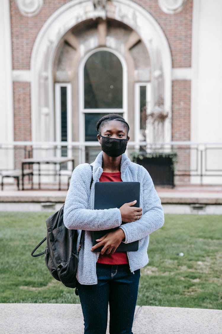 Unrecognizable Black Student With Laptop Against Old Building In Town