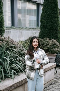 郁郁葱葱的绿色植物环绕着城市中休闲的年轻女性