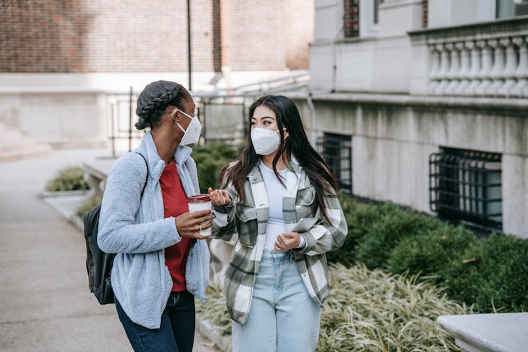 Diverse Female Teens Standing Near College Building And Chatting