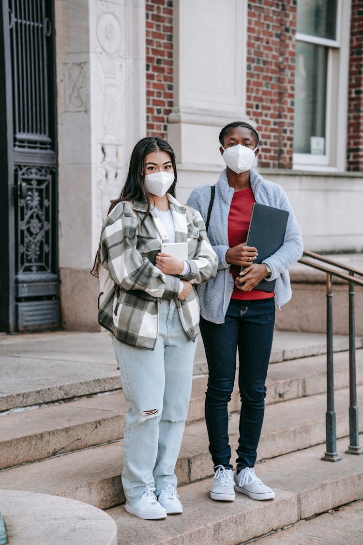 Young Diverse Female Friends Standing On Stairs Of University After Studies