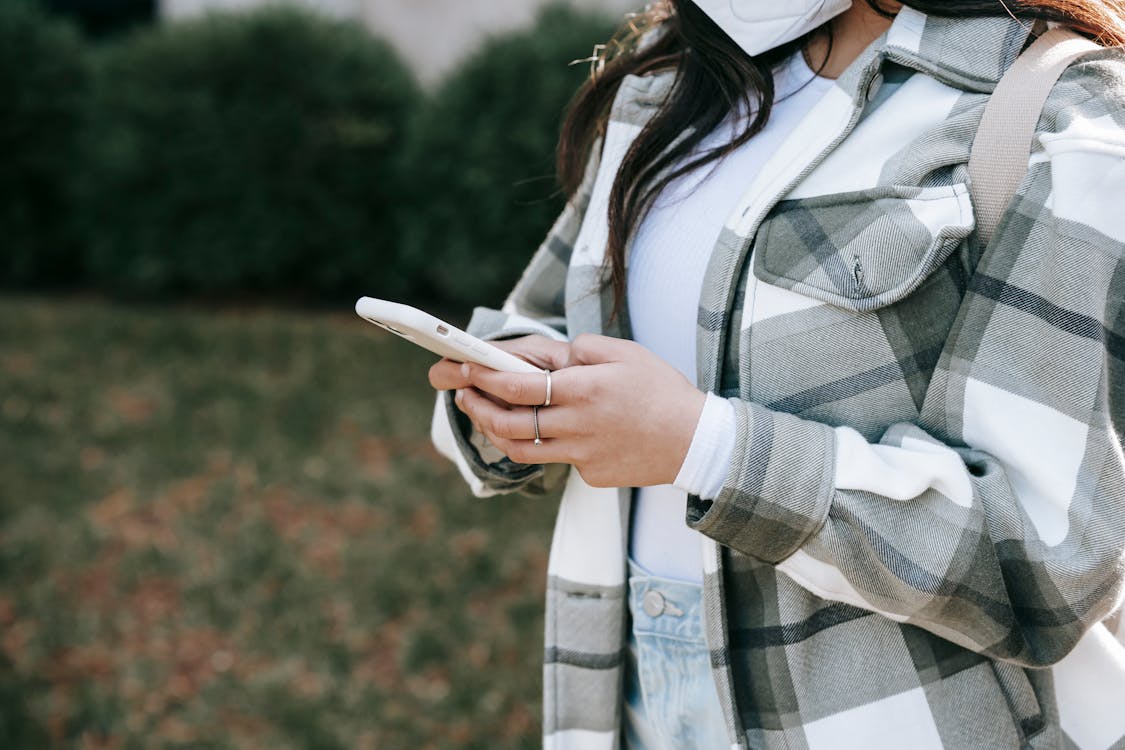 Free Faceless lady with mobile in street Stock Photo