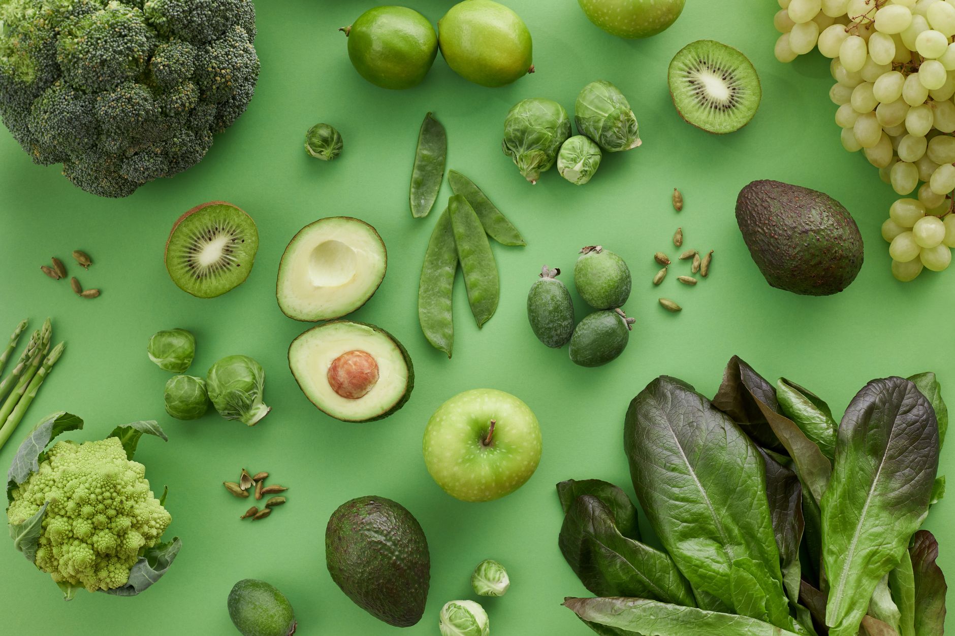 Ultimate Low Carb Broccoli Apple Salad Guide 1 Top view of assorted fresh green vegetables and fruits on a green background, perfect for healthy lifestyle visuals.