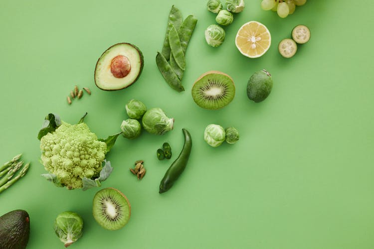 Slices Of Fruits Beside Green Vegetables