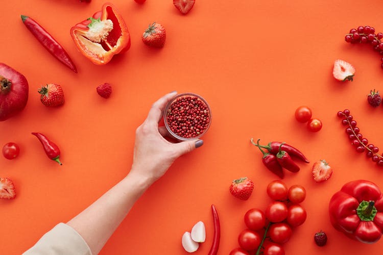 Close-Up Shot Of Red Fruits And Vegetables On A Red Surface