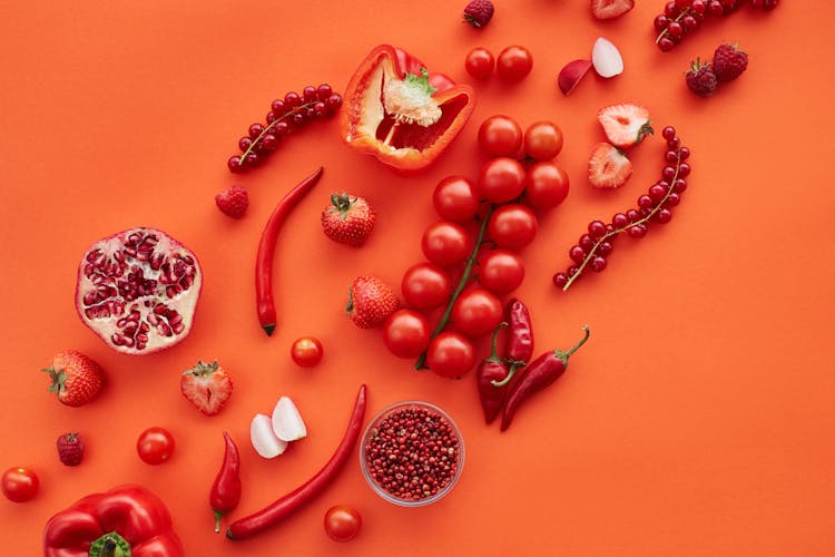 Close-Up Shot Of Red Fruits And Vegetables On A Red Surface