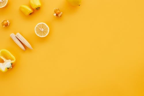 Sliced Lemon and Vegetables on Yellow Surface