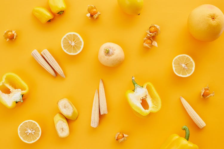 Close-Up Shot Of Yellow Fruits And Vegetables On A Yellow Surface