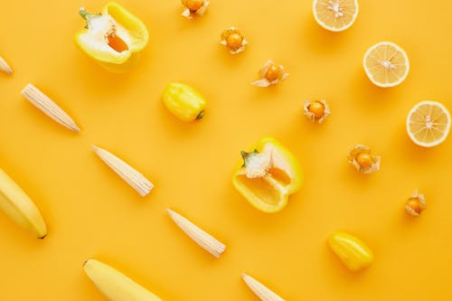 Slices of Vegetables and Fruits on Yellow Surface