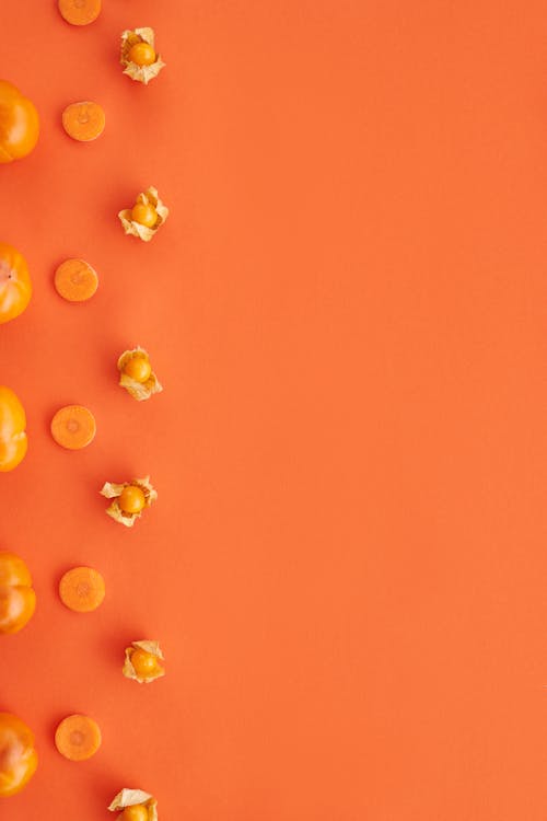 Close-Up Shot of Orange Fruits and Vegetables on an Orange Surface