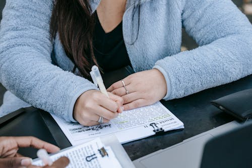 Crop unrecognizable diverse women doing paperwork together