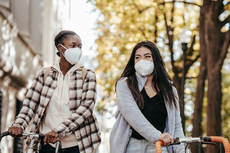 Diverse Friends In Protective Masks With Bicycles