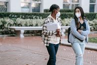 Multiethnic students with folders walking in park