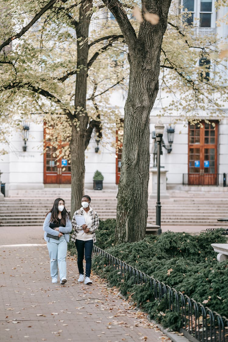 Diverse Students Walking In University Park Together