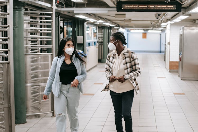 Diverse Friends In Masks Walking In Underground