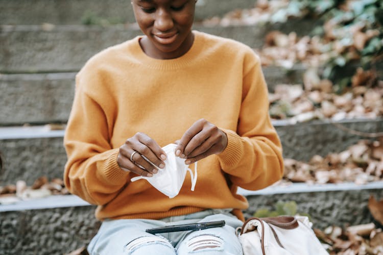 Crop Positive Black Woman Putting On Mask In Park