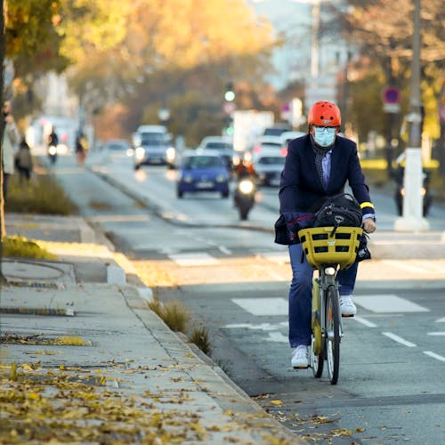 Man in Blazer Riding Bicycle on the Road
