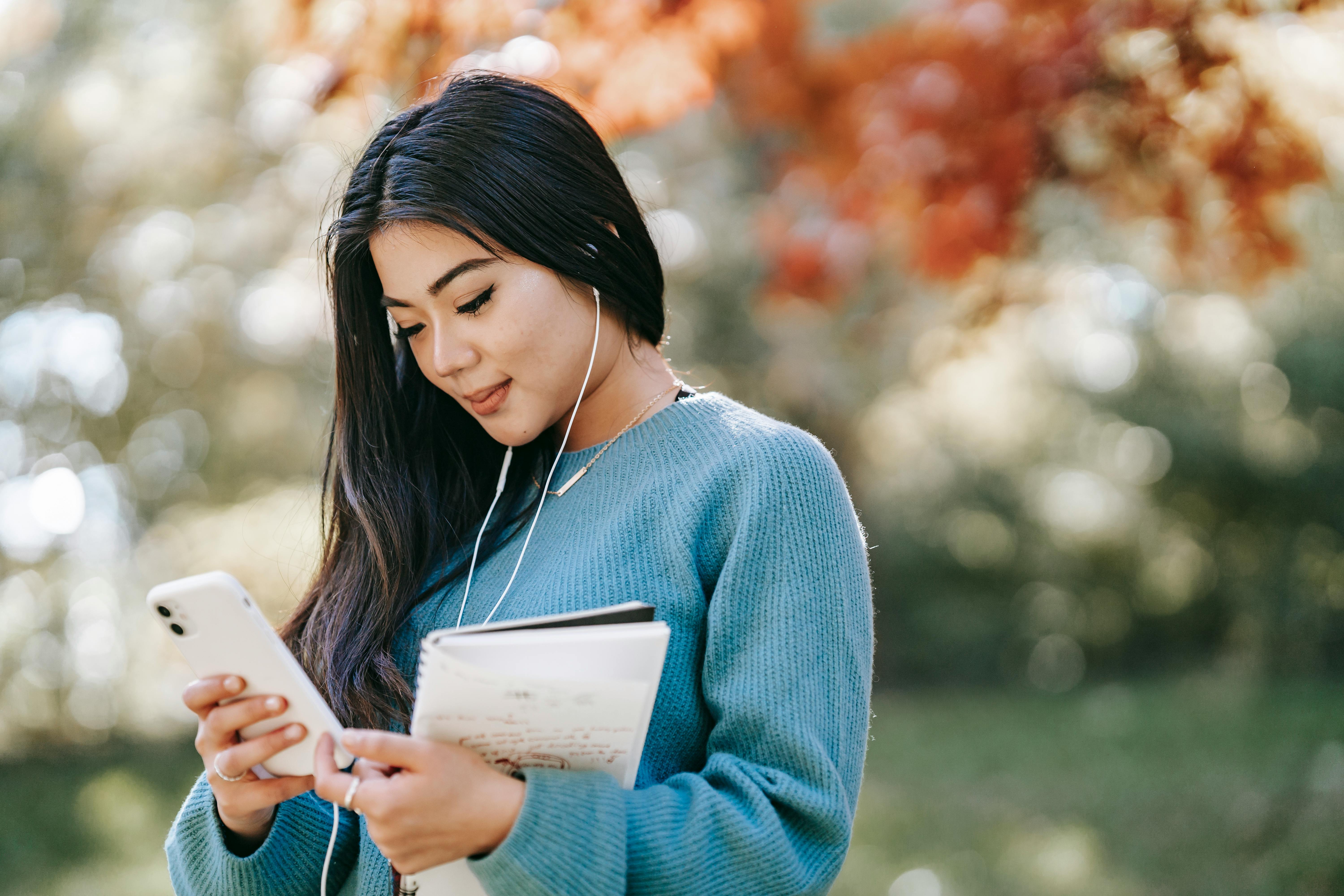 young cheerful woman listening to music using smartphone