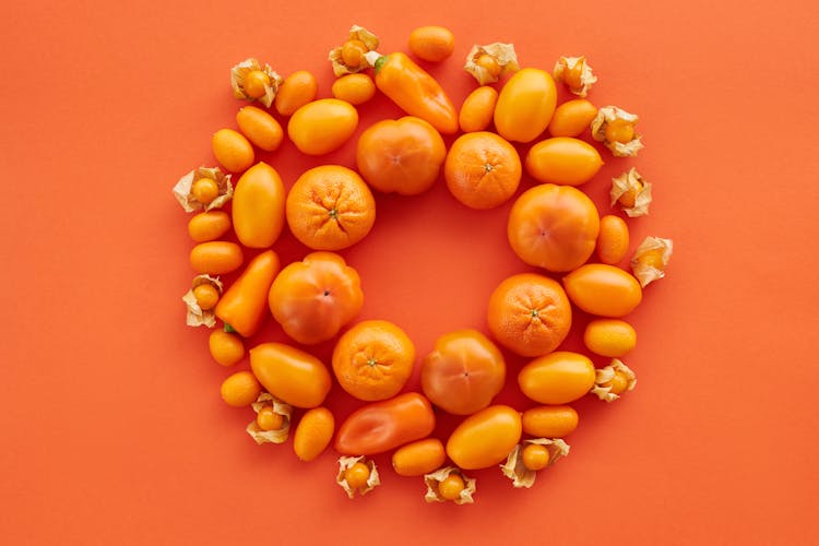 Assorted Fruits And Peppers On Orange Background