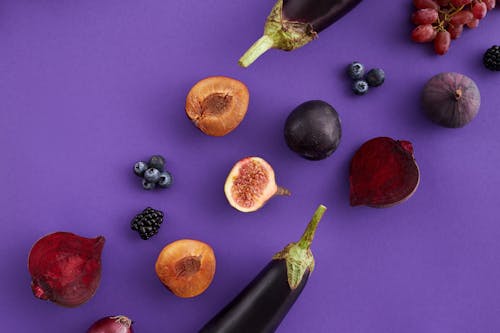 Close-Up Shot of Purple Fruits and Vegetables on a Purple Surface