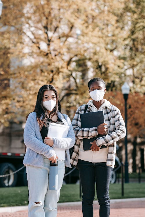 Young students with folders on city street