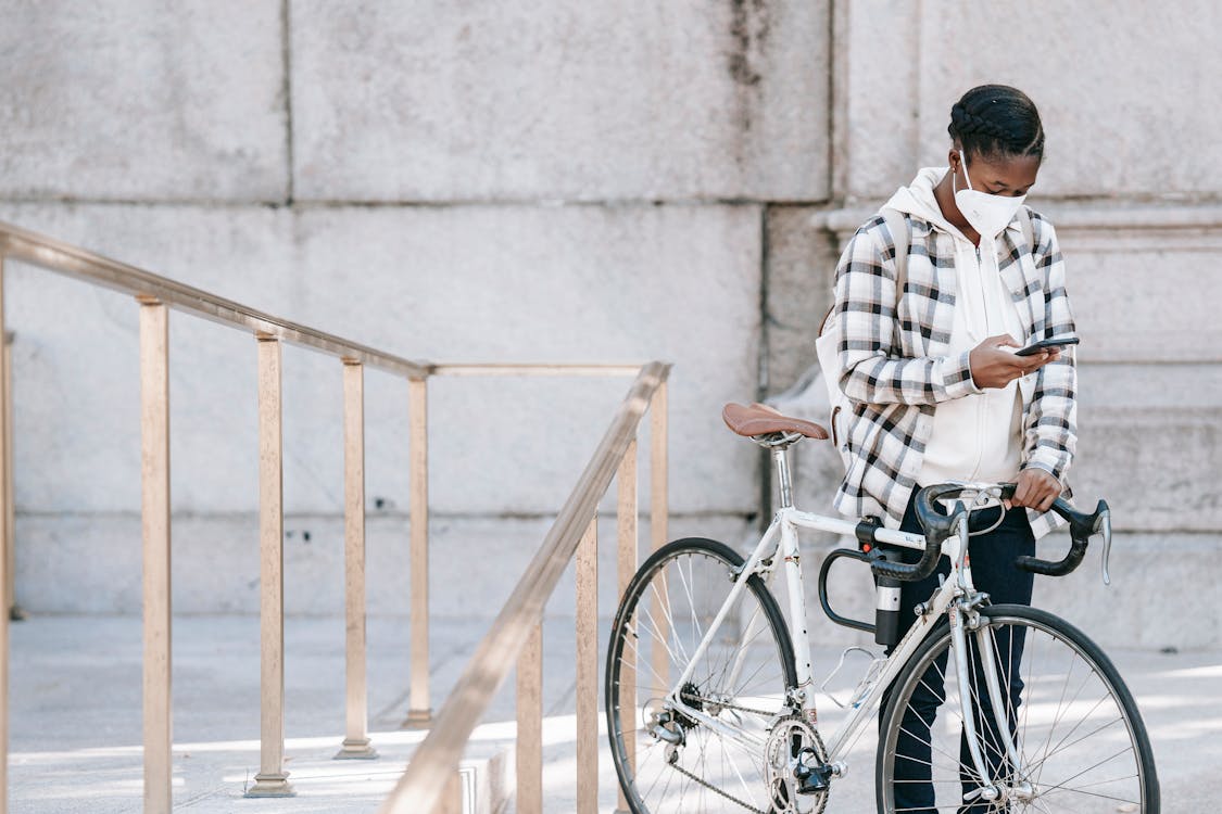 African American woman with smartphone and bicycle