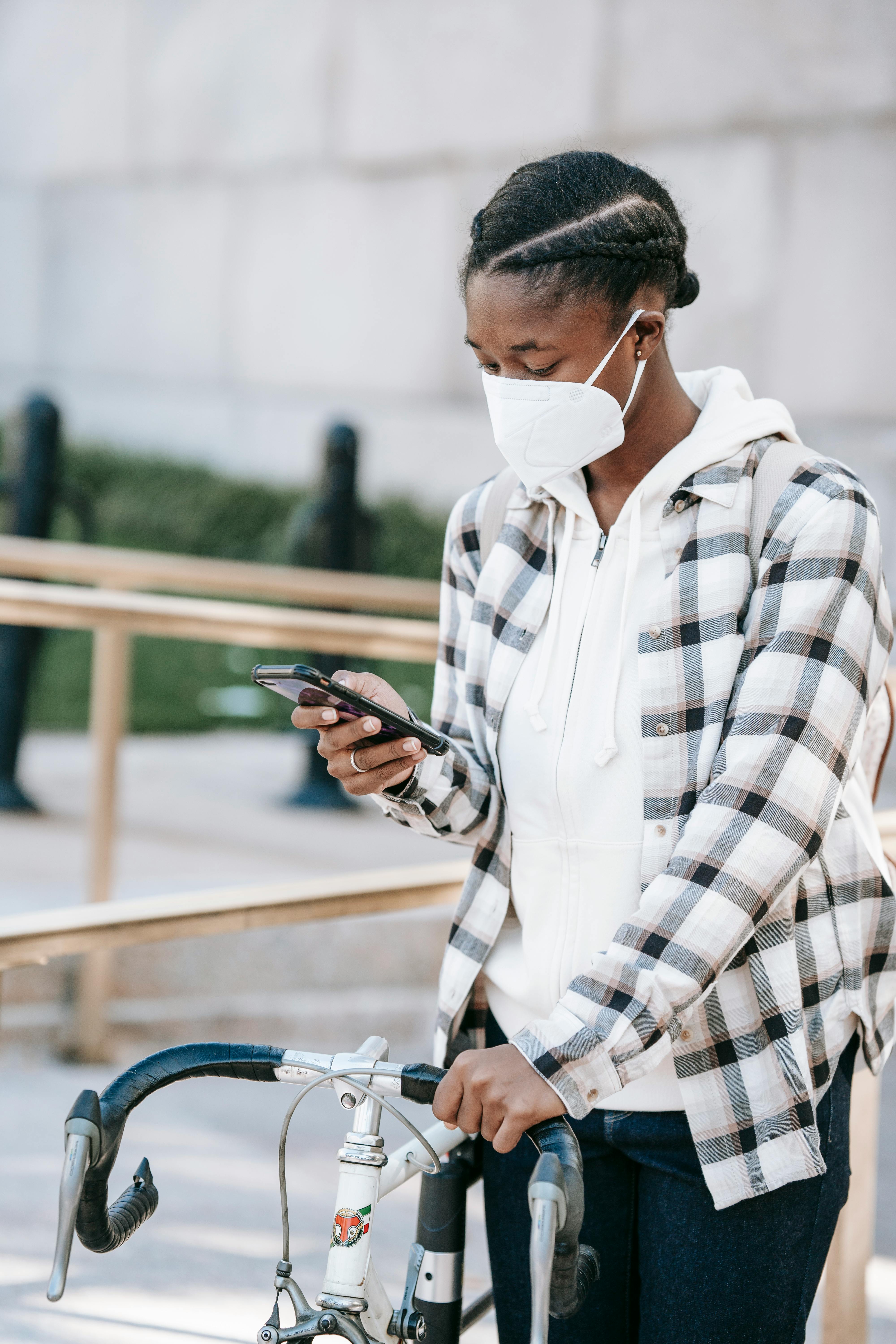 black woman with bicycle and smartphone