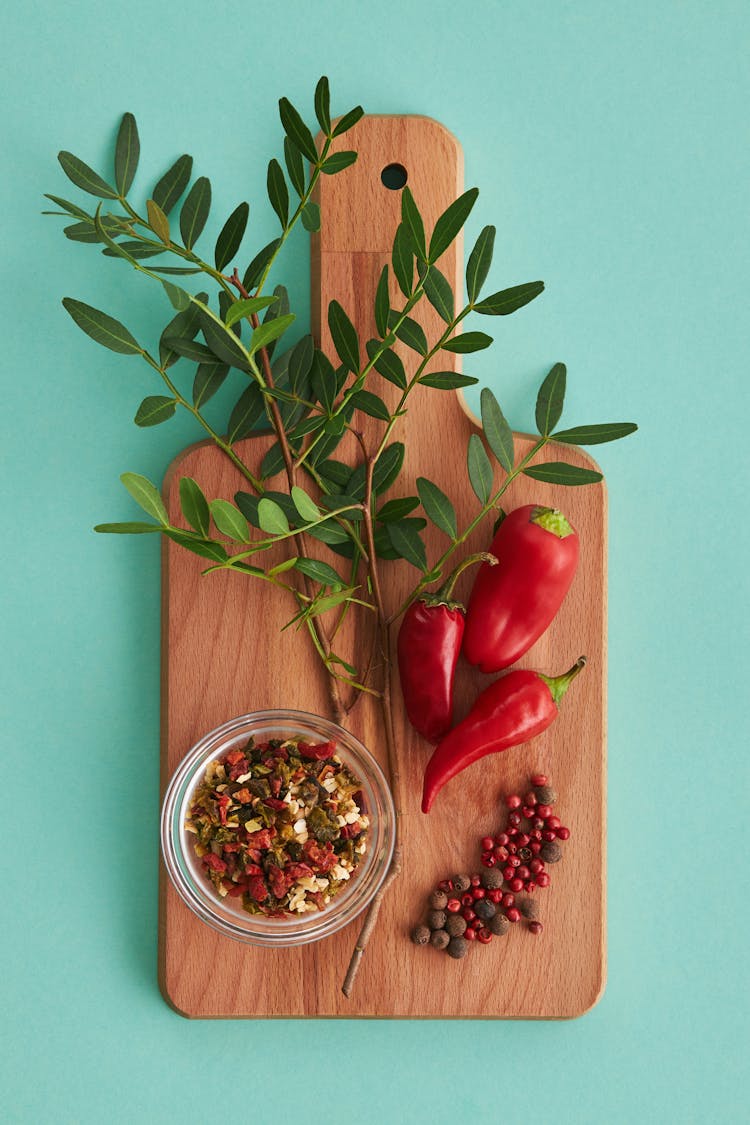 Red Chili And Green Leaves On White Ceramic Bowl