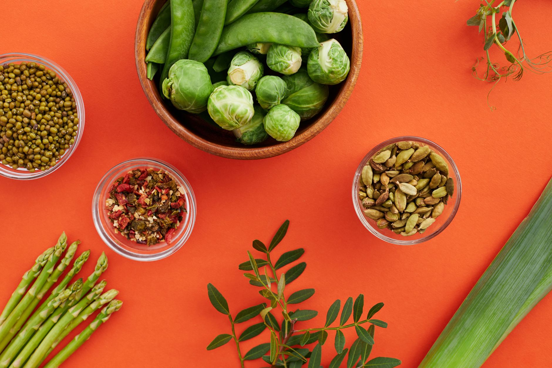 Vibrant display of nutritious vegetables and spices on a bold red background.