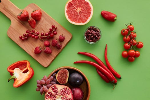 Top view of a vibrant selection of fruits and vegetables on a green background.