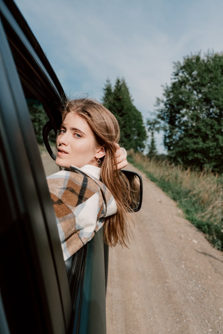 A Brown-Haired Woman Peeking Out Of The Car Window