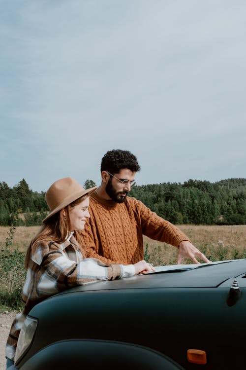 Free Couple Standing in Front of Car Hood Stock Photo