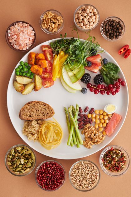 Flatlay de alimentos nutritivos variados sobre superfície clara — fontes de proteínas incluindo ovos, nozes e leguminosas