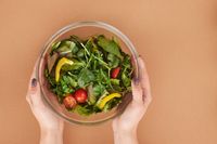 Bol de salade fraîche tenu dans les mains, illustration d'une alimentation équilibrée au quotidien
