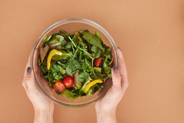 Bol de salade fraîche tenu dans les mains, illustration d'une alimentation équilibrée au quotidien