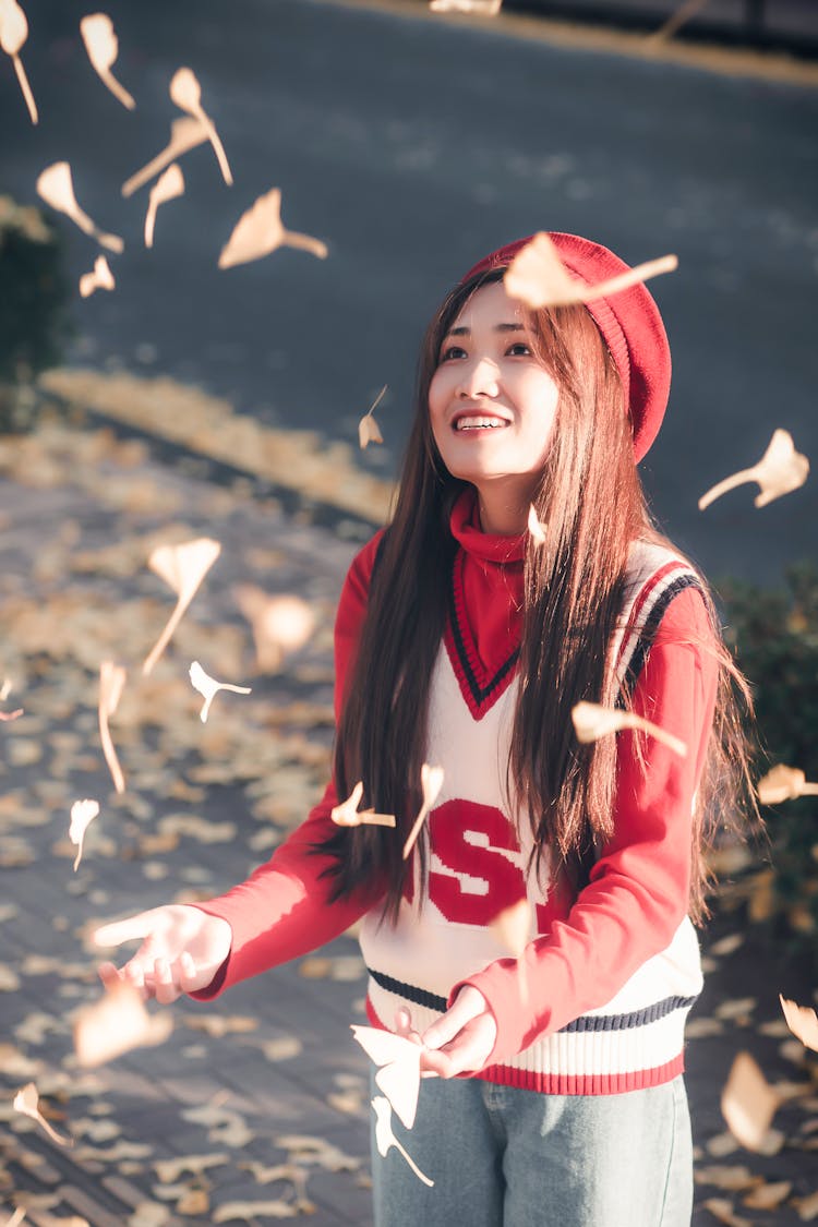 Woman In Red And White Shirt Catching Falling Leaves