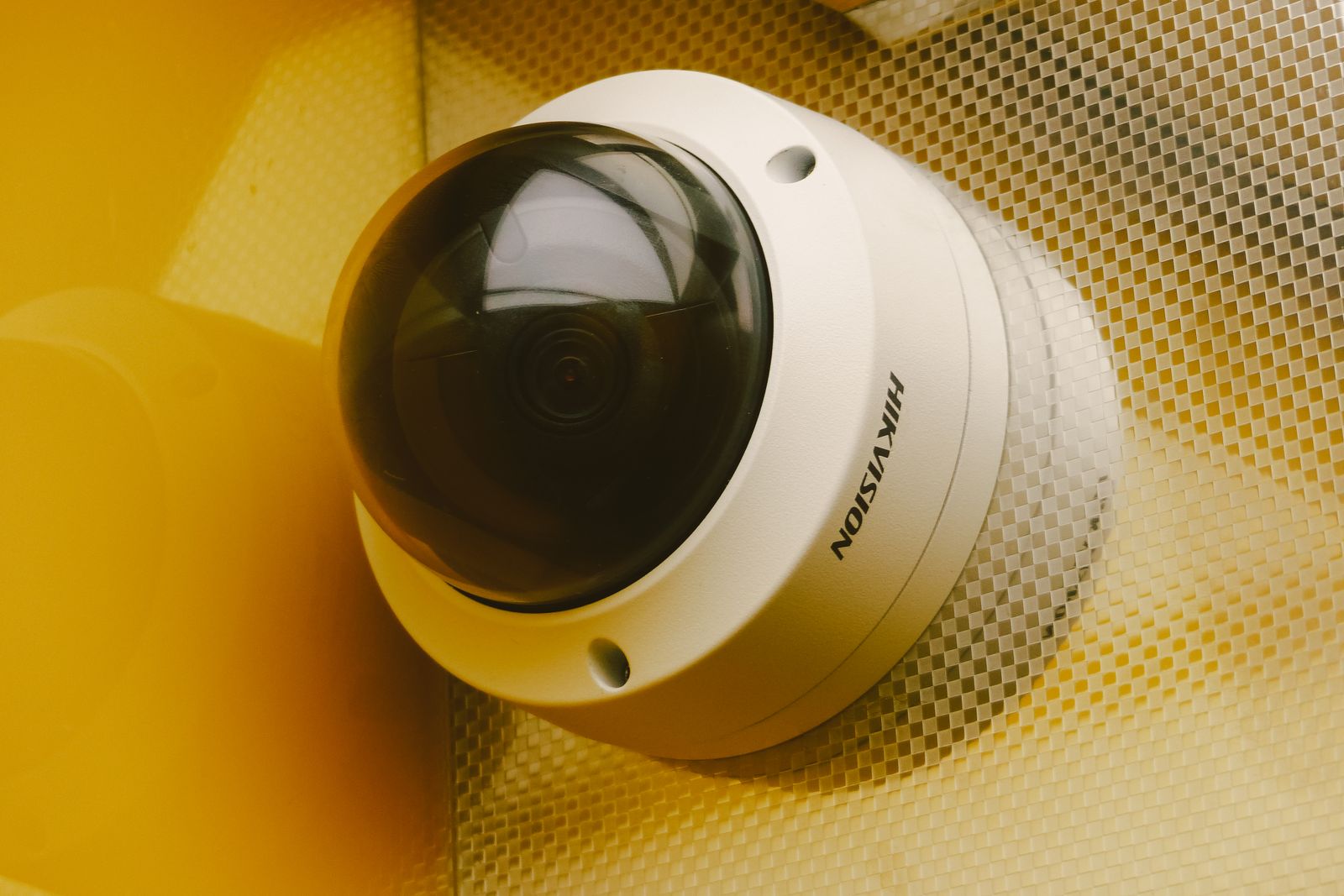 Cámara de videovigilancia moderna instalada en la pared de un edificio, vista desde abajo