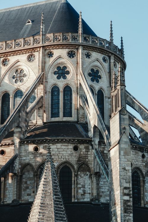 Free Facade of aged saint church with ornamental elements under windows and brick tower against cloudless blue sky Stock Photo