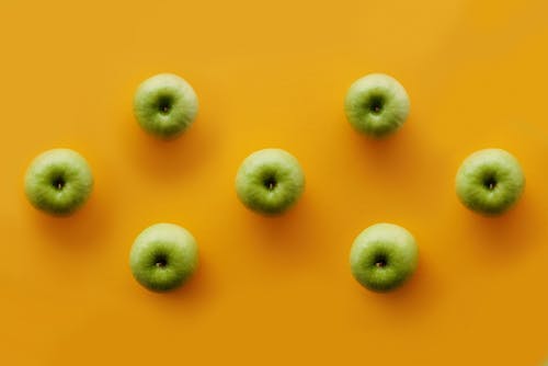 Green Apples on Yellow Surface