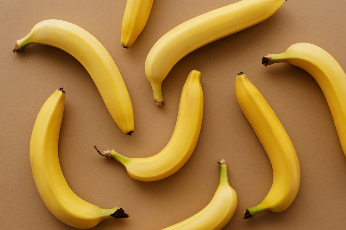 Gratis Frutos De Plátano Amarillo Sobre Superficie Marrón Foto de stock